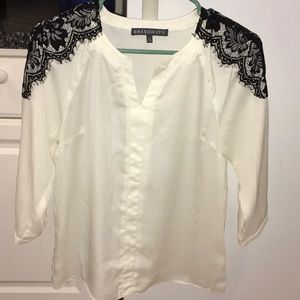 White blouse with black lace detail on shoulders